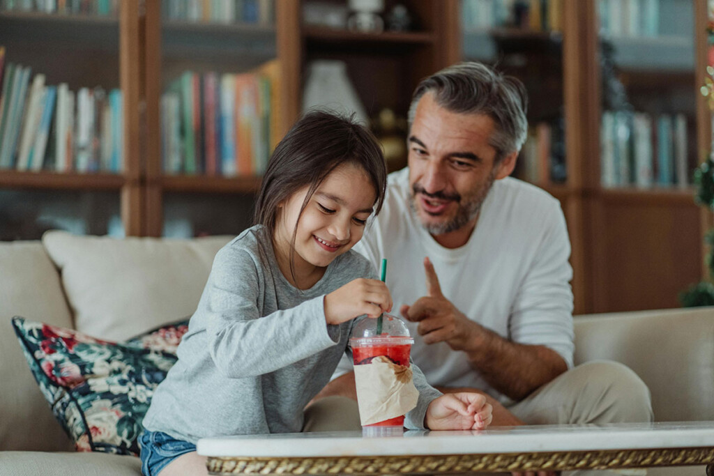 Father and daughter enjoying a smoothie